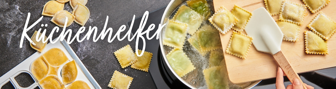 Ravioli kochen. Küchenhelfer. Nudeln in kochendem Wasser. Holzbrett und Spatel.