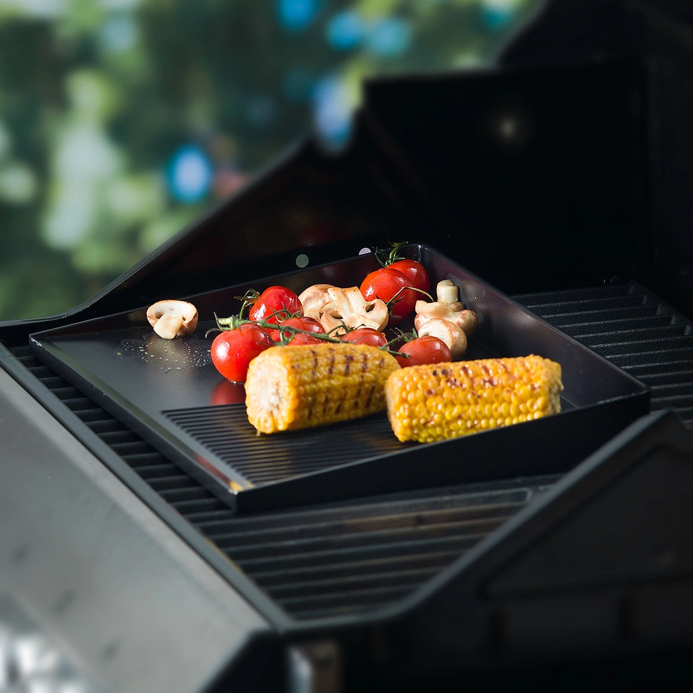 Légumes sur plaque de cuisson : tomates, champignons, épis de maïs, barbecue