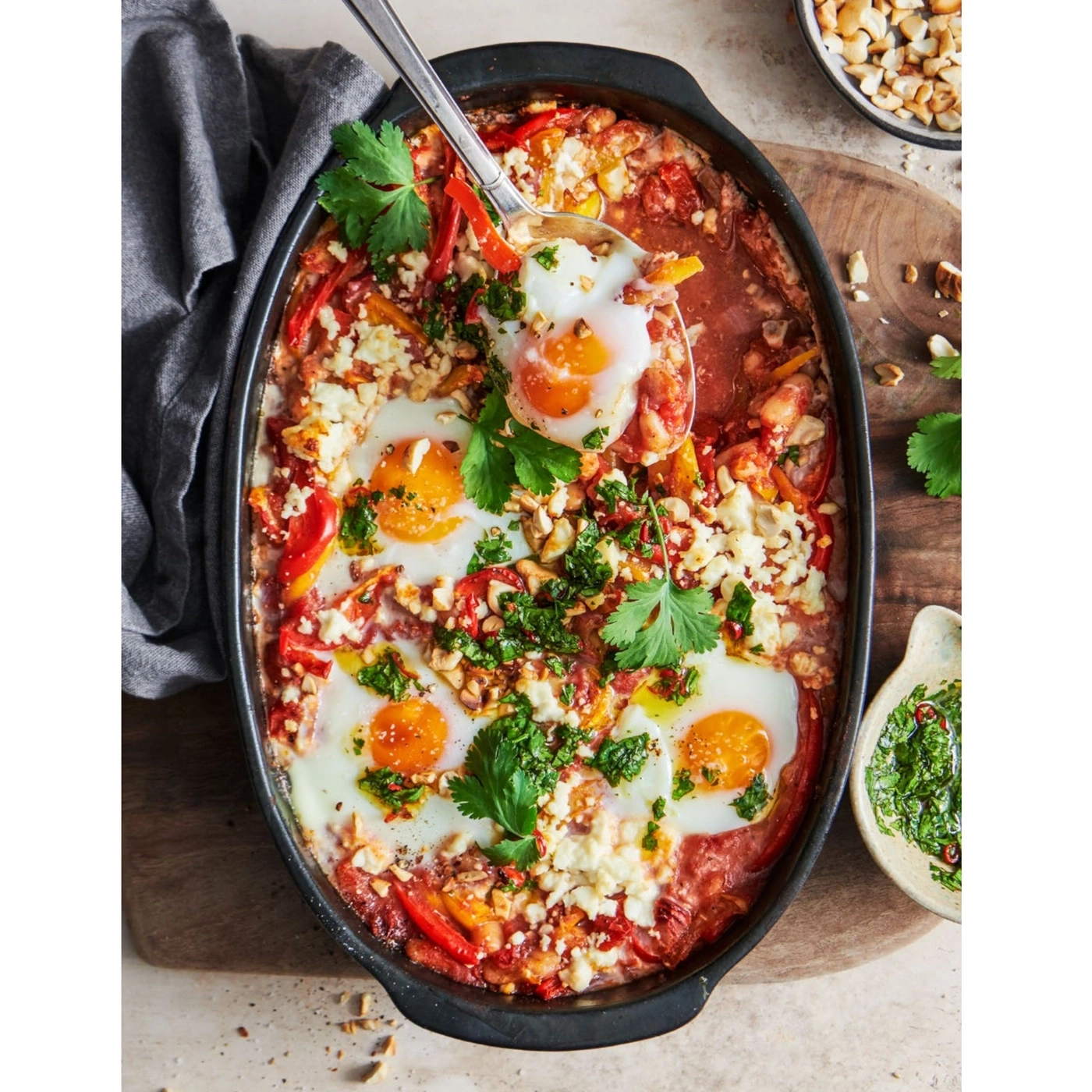 Eier in Tomatensauce mit Käse, Kräutern und Nüssen in einer Auflaufform