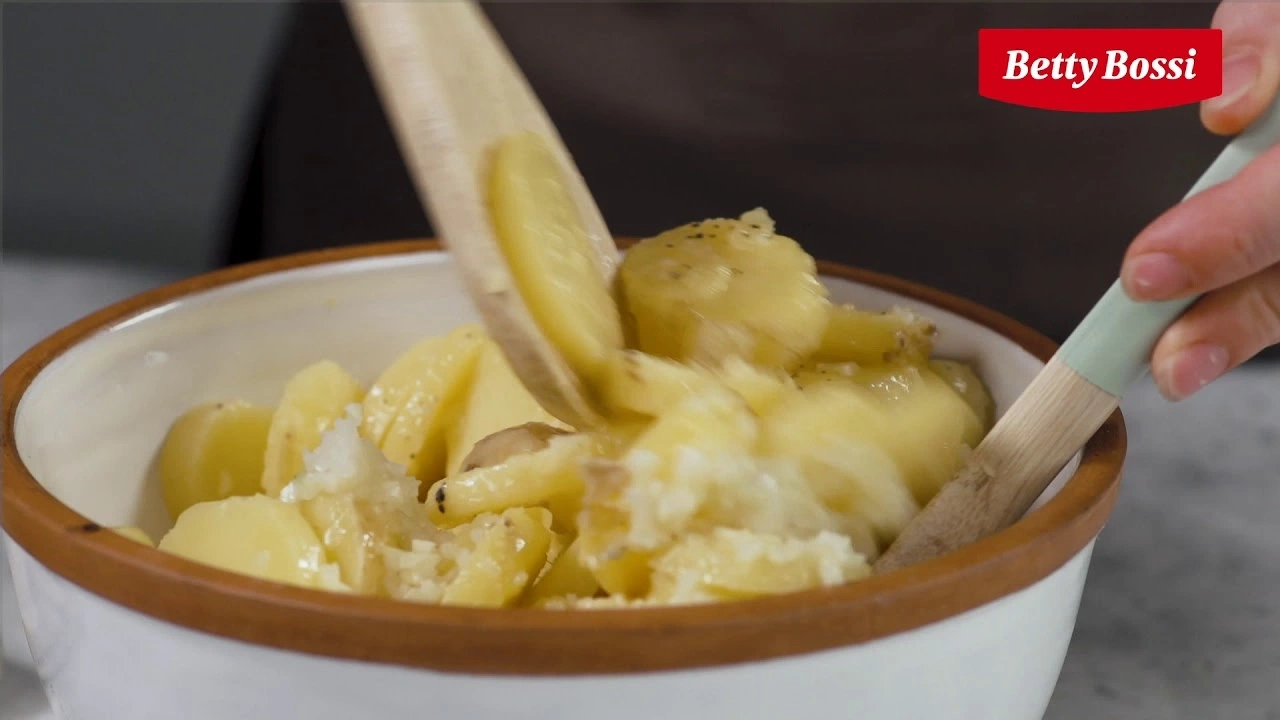 Kartoffeln in einer Schüssel mit einem Holzlöffel verrühren, Betty Bossi Logo.