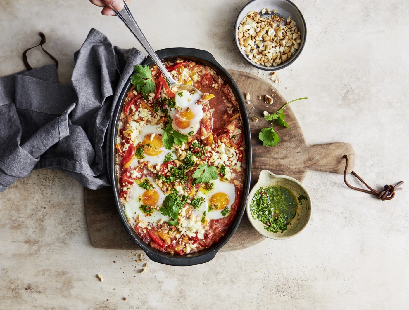 Plat d'œufs aux tomates, poivrons, herbes, fromage et noix, servi avec une sauce