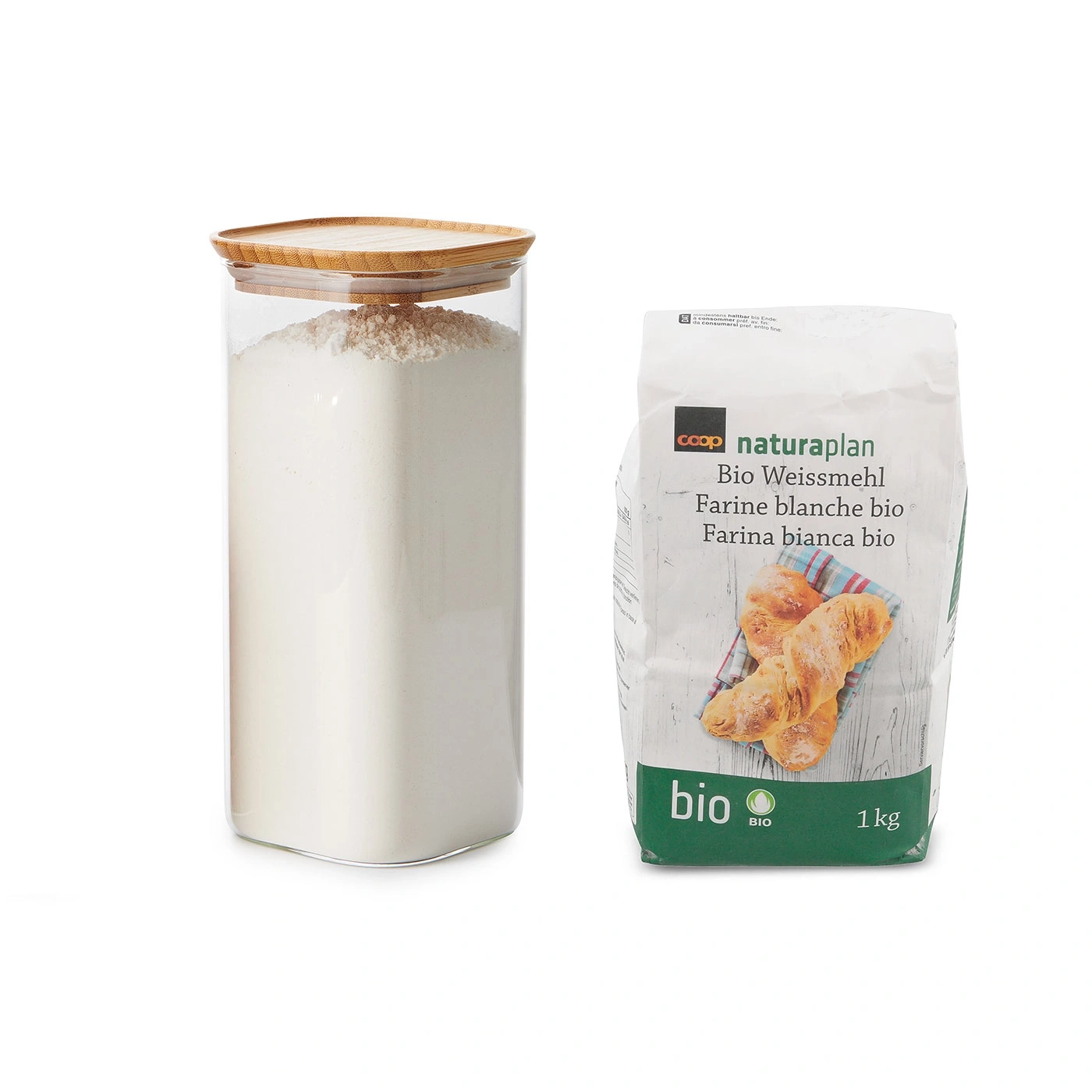 Glasbehälter mit Mehl und Bio-Mehlpackung mit 1 kg Inhalt.