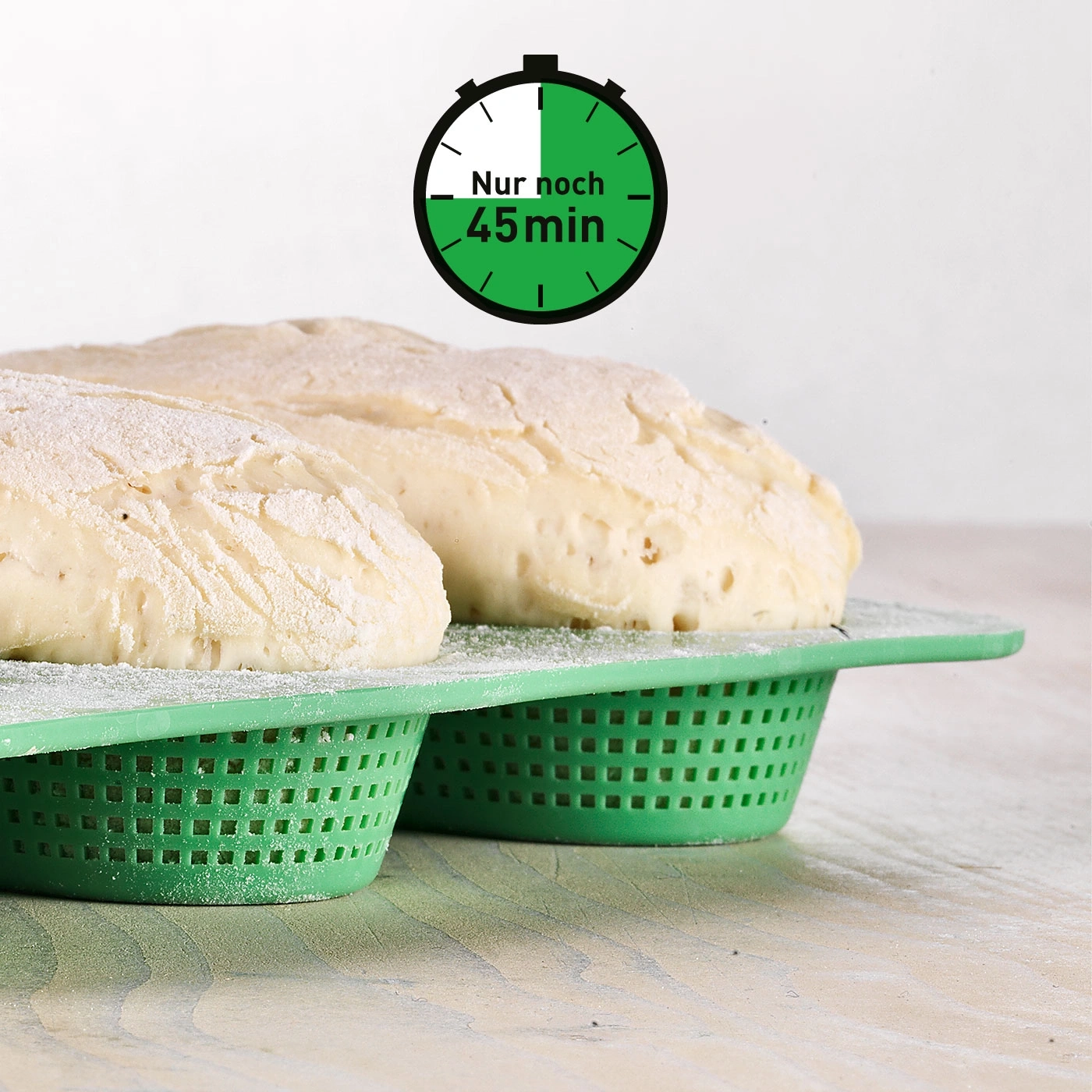 Brotlaibe in grünen Körben mit Uhr, die 45 Minuten anzeigt.