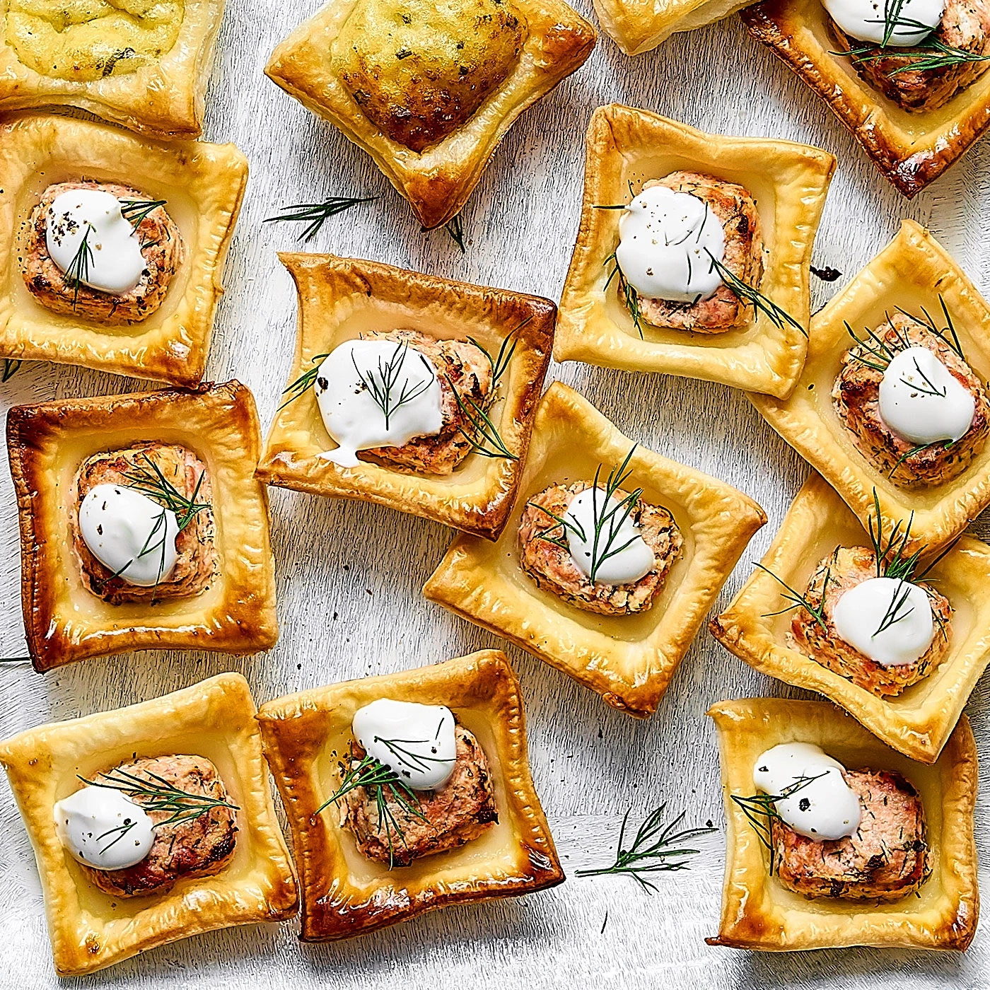 Köstliche Lachshäppchen mit Sahne und Dill auf einem weißen Tisch