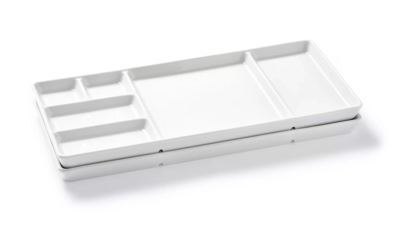 Plat de service blanc à plusieurs compartiments, empilé sur fond blanc.