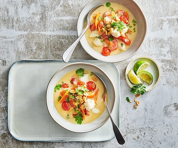 Zwei Schalen Suppe mit Gemüse und Erdnüssen, Limetten, auf Tablett