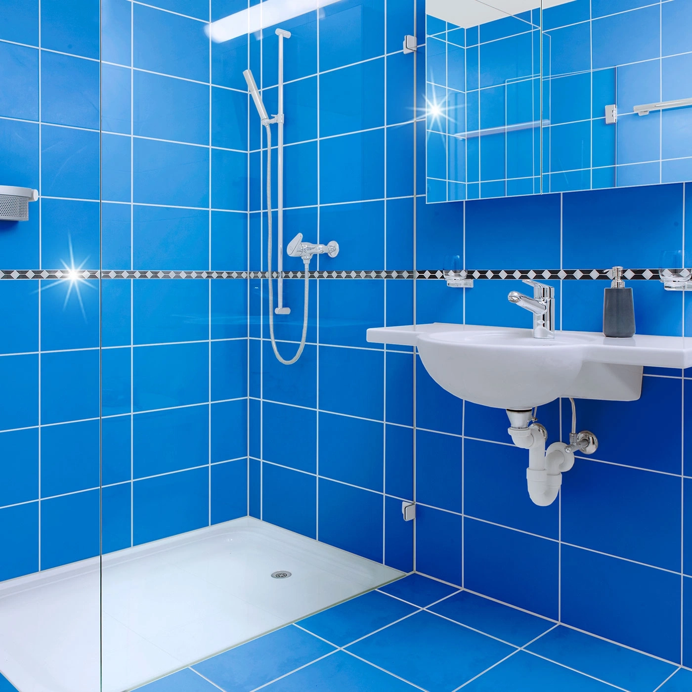 Blaues Badezimmer mit blauen Fliesen, Dusche, Waschbecken und Spiegel.