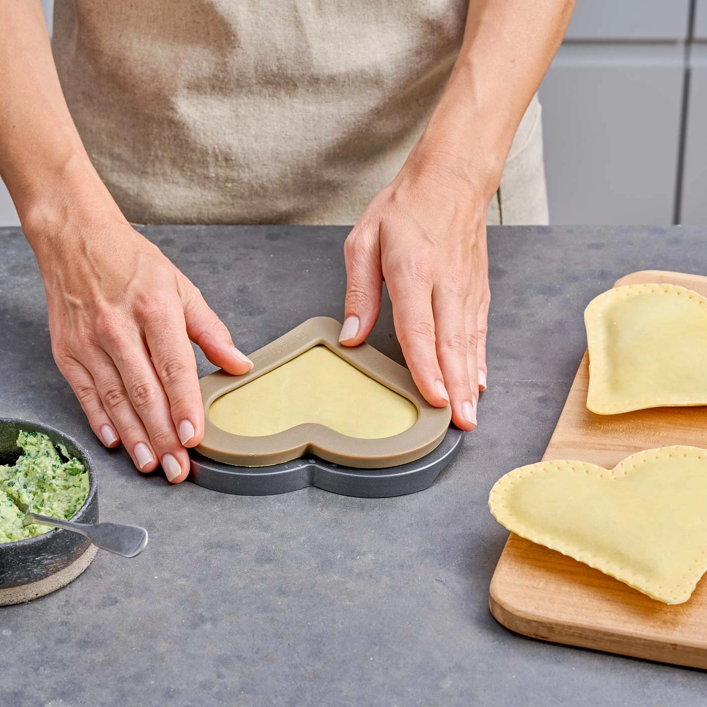 Personne préparant des raviolis. Forme de cœur, pâte, garniture, cuisine, mains.