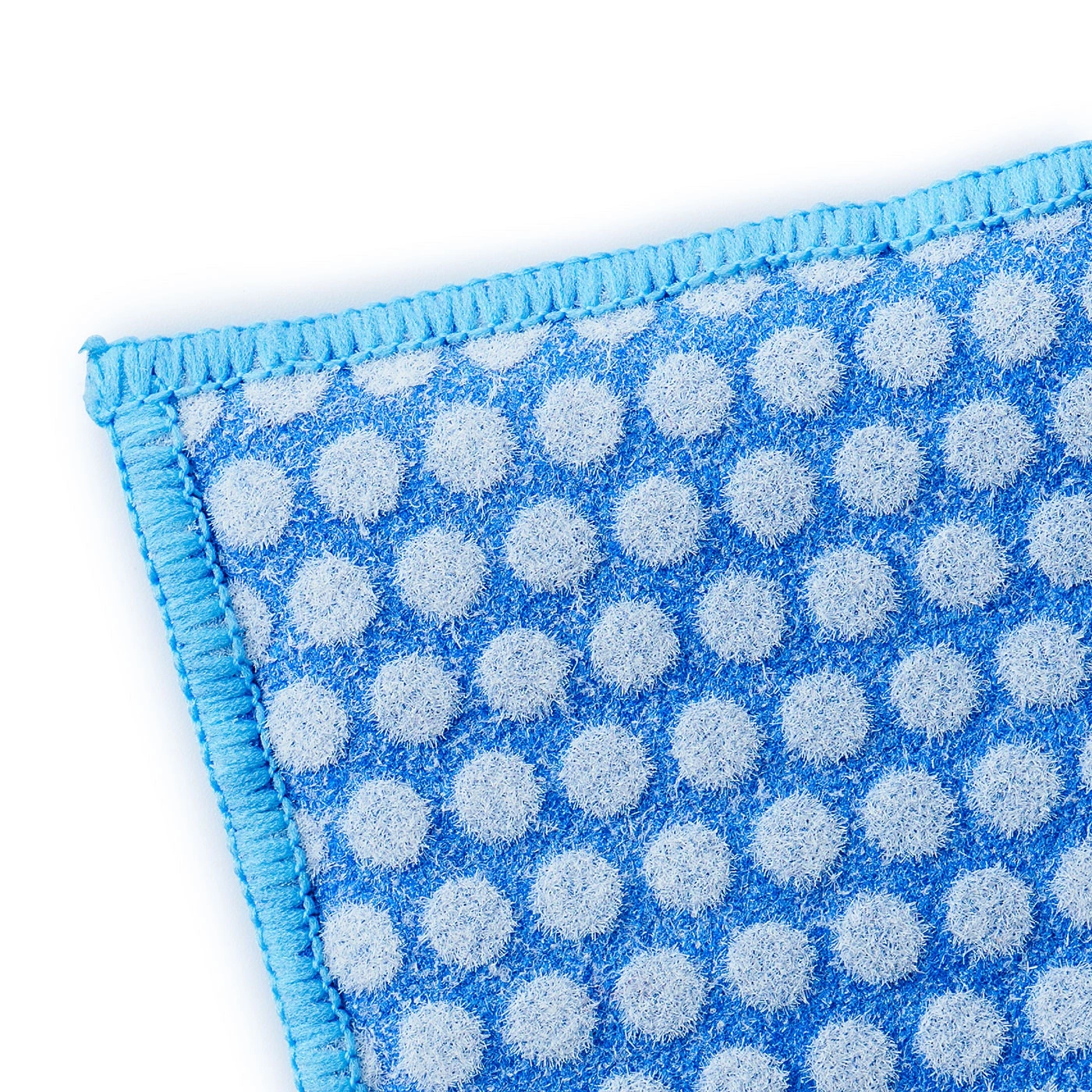 Éponge bleue à pois blancs et bordure bleue, gros plan, isolée sur fond blanc