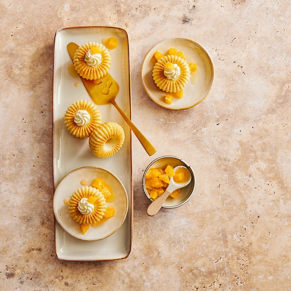 Dessert mit Kuchen, Sahne und Früchten auf einem Tisch, Nahaufnahme