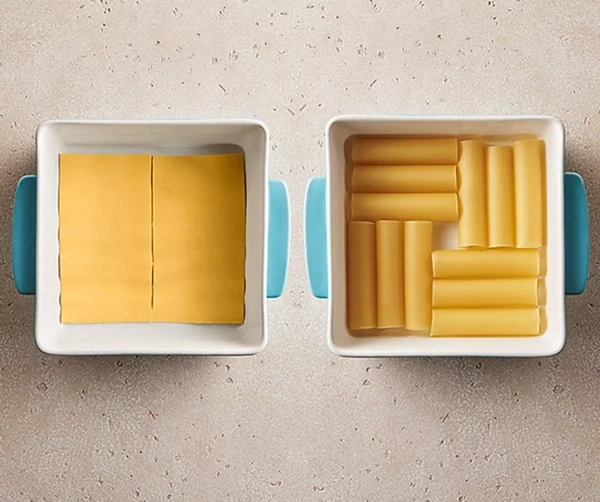 Zwei Auflaufformen mit Käse und Nudelröhren