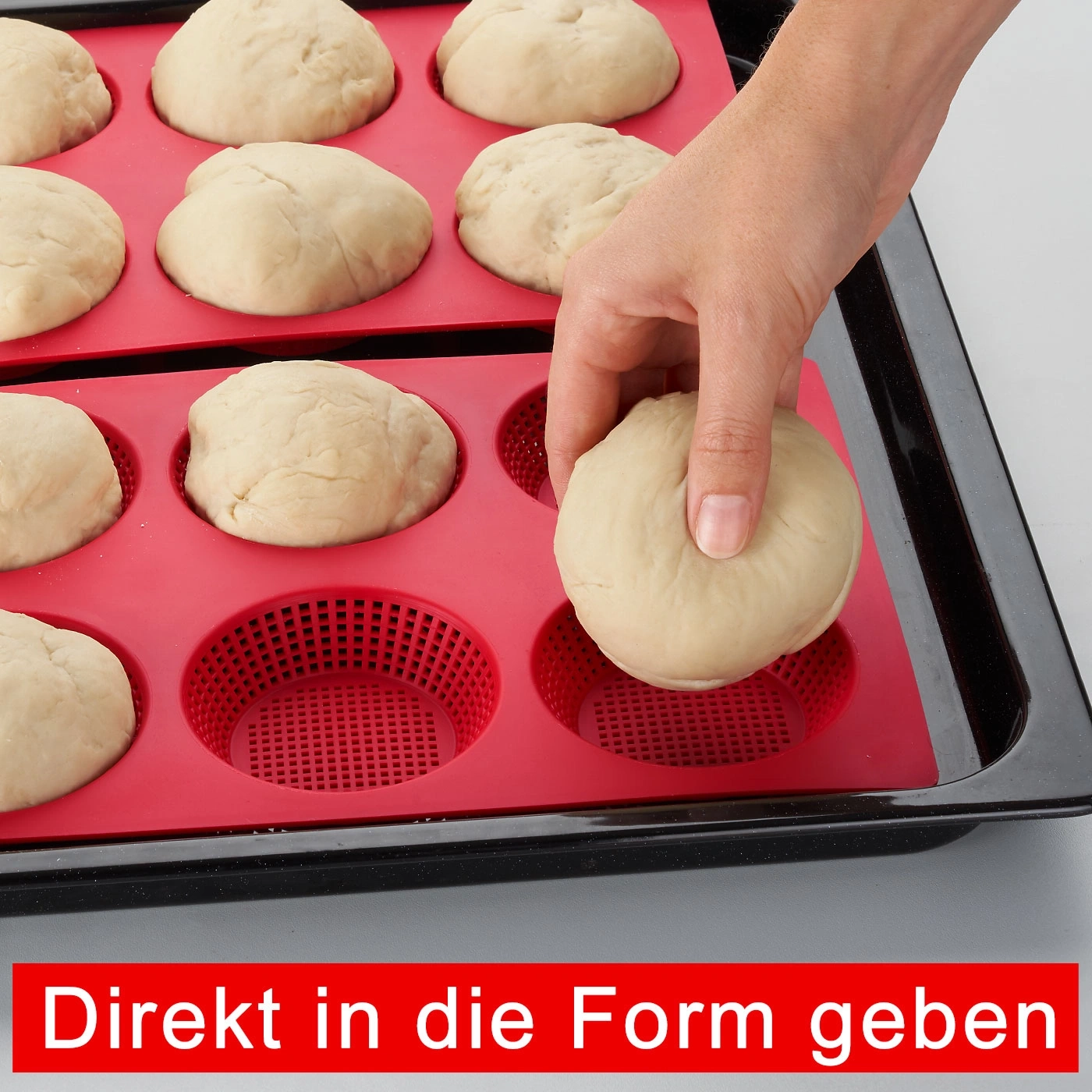 Hand legt Teig in rote Backform. Brotbacken, Küche, Backen, Teig, Backblech, Backform.