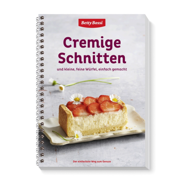 Ein Buch mit dem Titel "Cremige Schnitten" zeigt ein Stück Erdbeerkuchen.