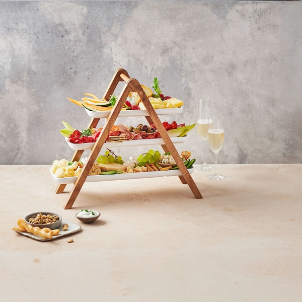 Plateau de service à trois niveaux avec collations et boissons, idéal pour une fête.