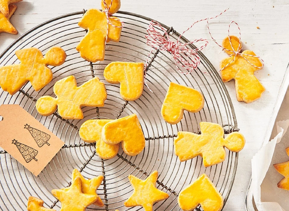 Weihnachtsplätzchen in verschiedenen Formen auf einem Rost mit Anhänger.