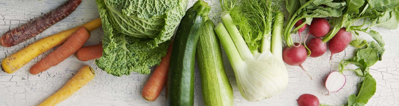 Gemüse auf weißem Holz. Karotten, Zucchini, Fenchel, Radieschen und Kohl.