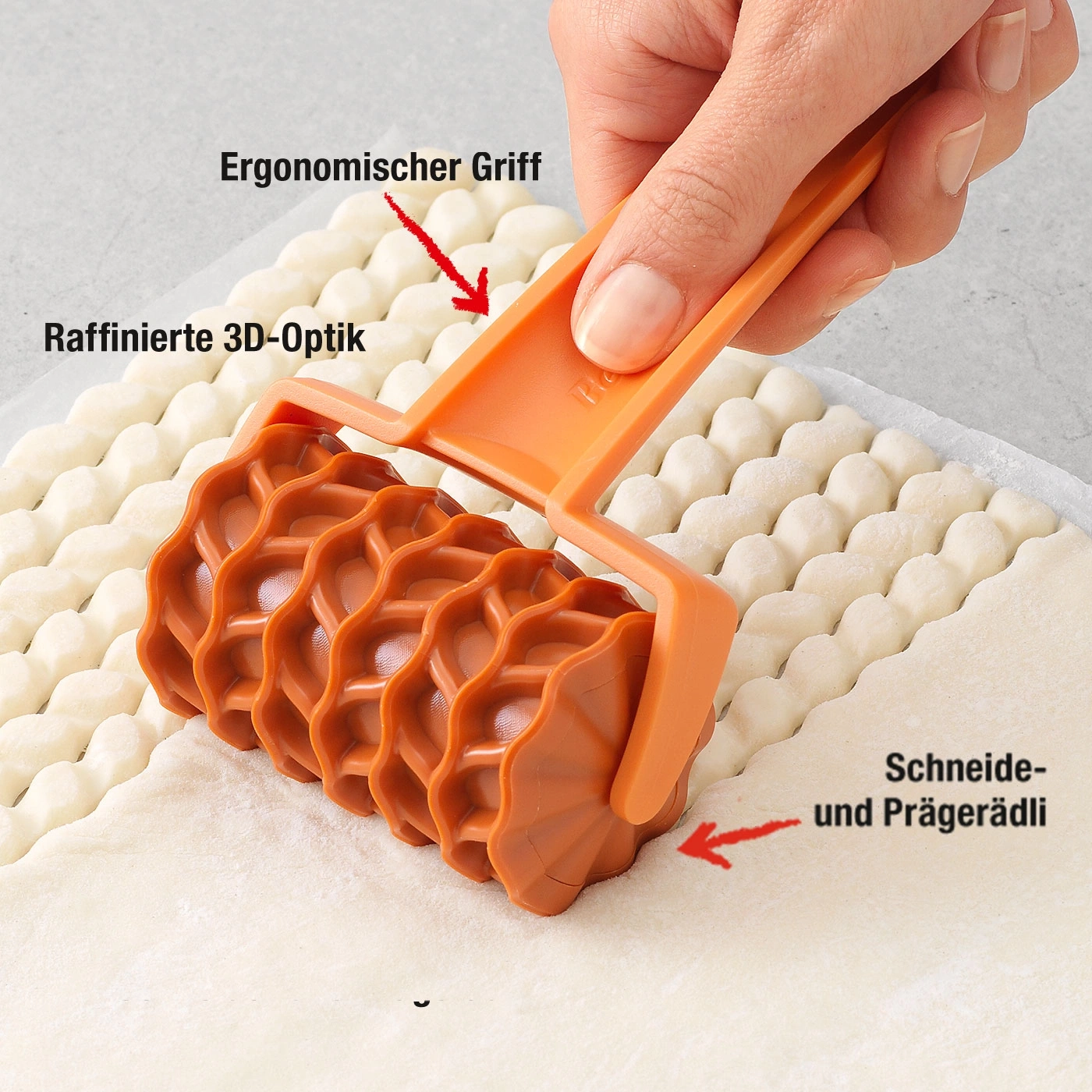 Orange Teigroller mit ergonomischem Griff und 3D-Optik, zum Schneiden und Prägen.