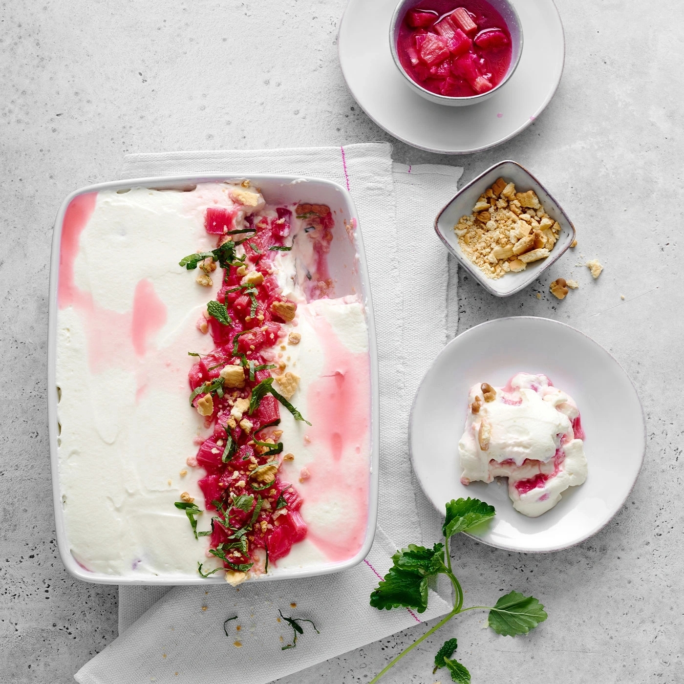 Dessert mit Rhabarber, Nüssen und Minze auf einem Teller. Lecker!