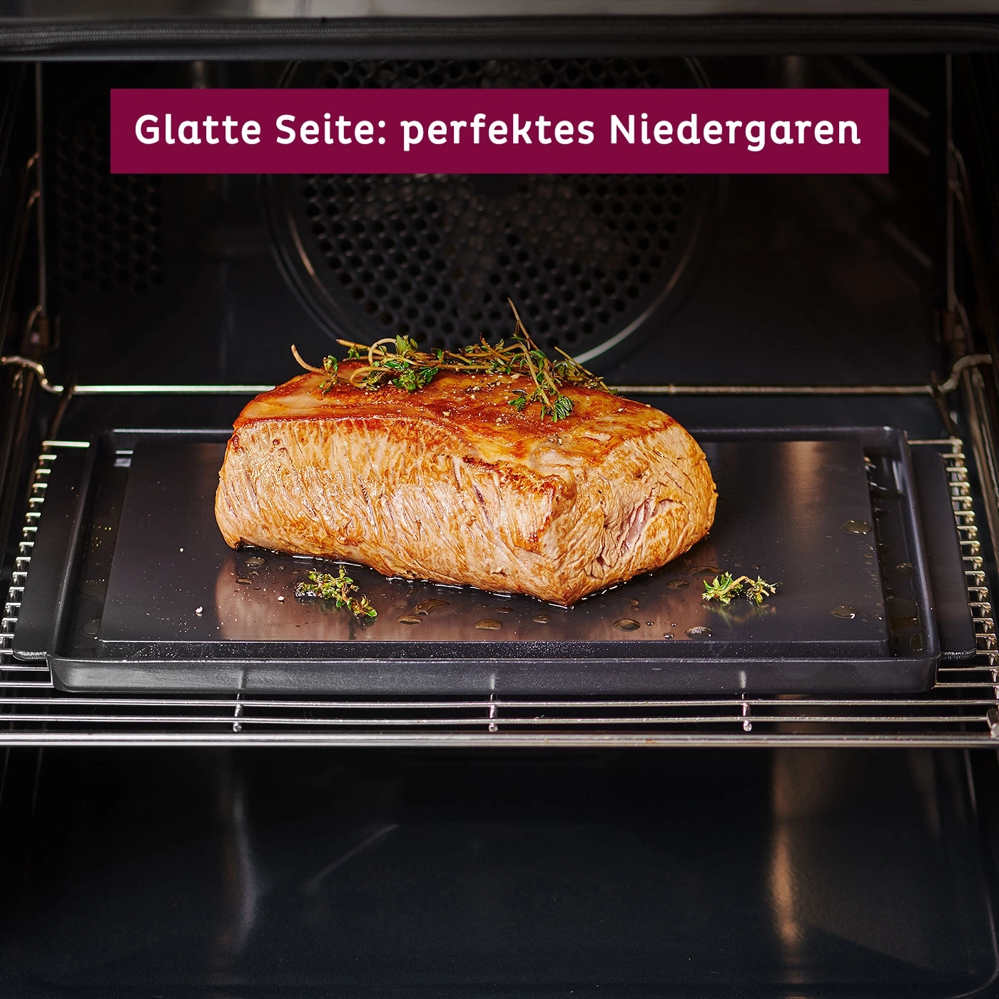 Viande rôtie au four, parfaitement cuite, sur un plateau noir avec des herbes aromatiques.
