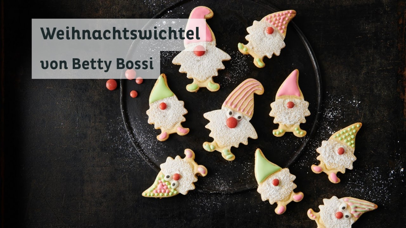 Weihnachtswichtel-Kekse von Betty Bossi auf einem dunklen Teller, dekoriert