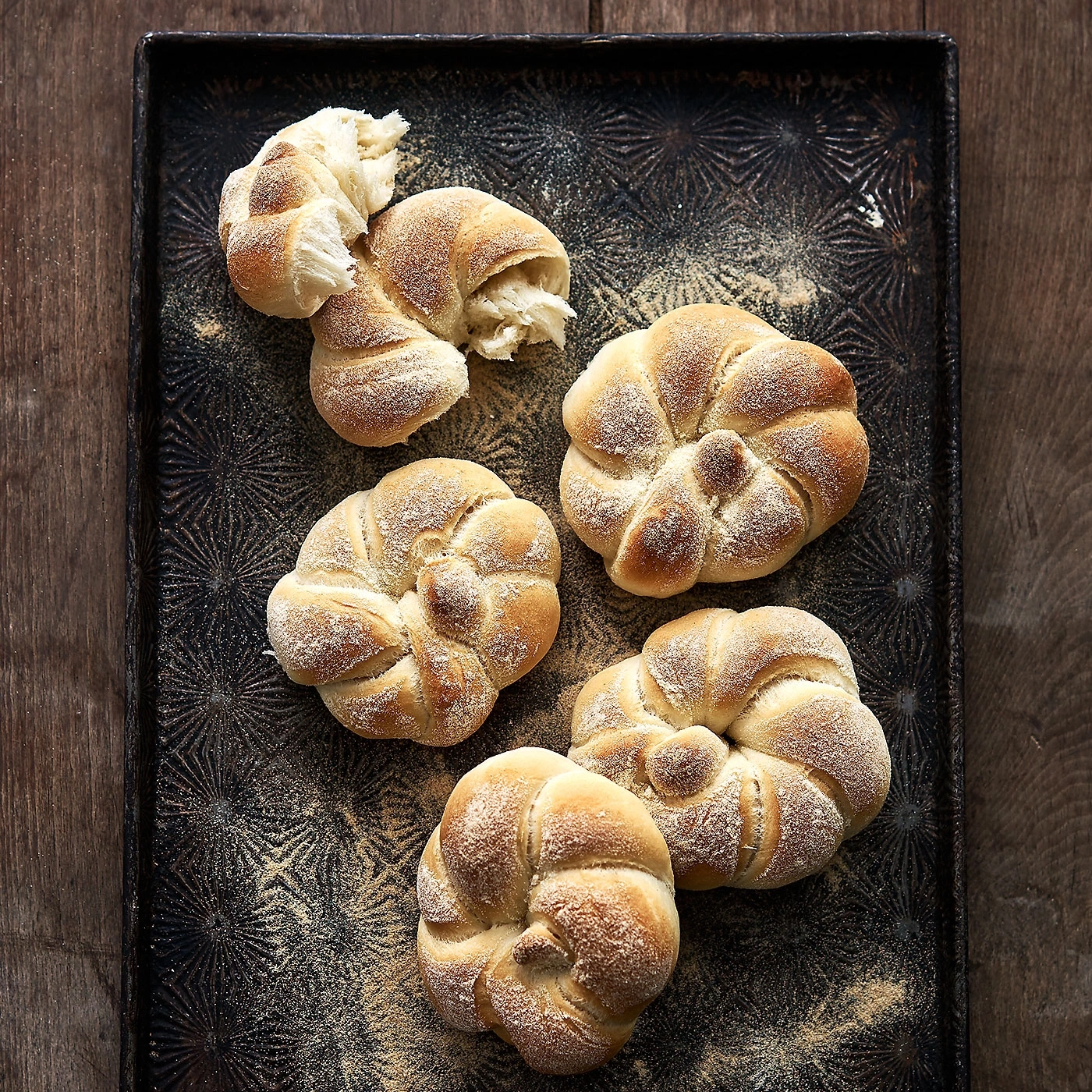 Du pain sur un plateau. Pâtisseries saupoudrées de farine sur un plateau.