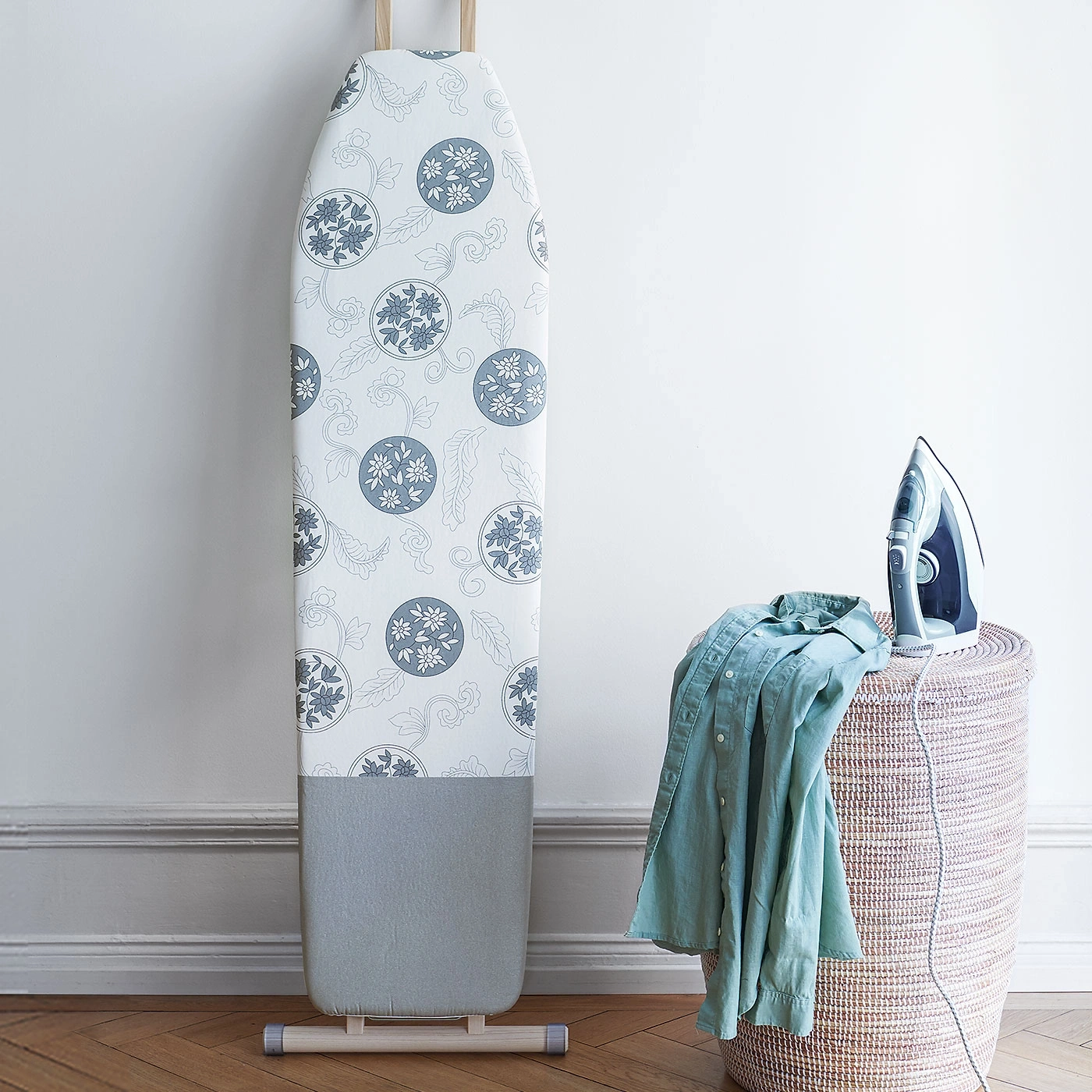Planche à repasser, fer à repasser, chemise sur panier, sol en bois, fond blanc, motif