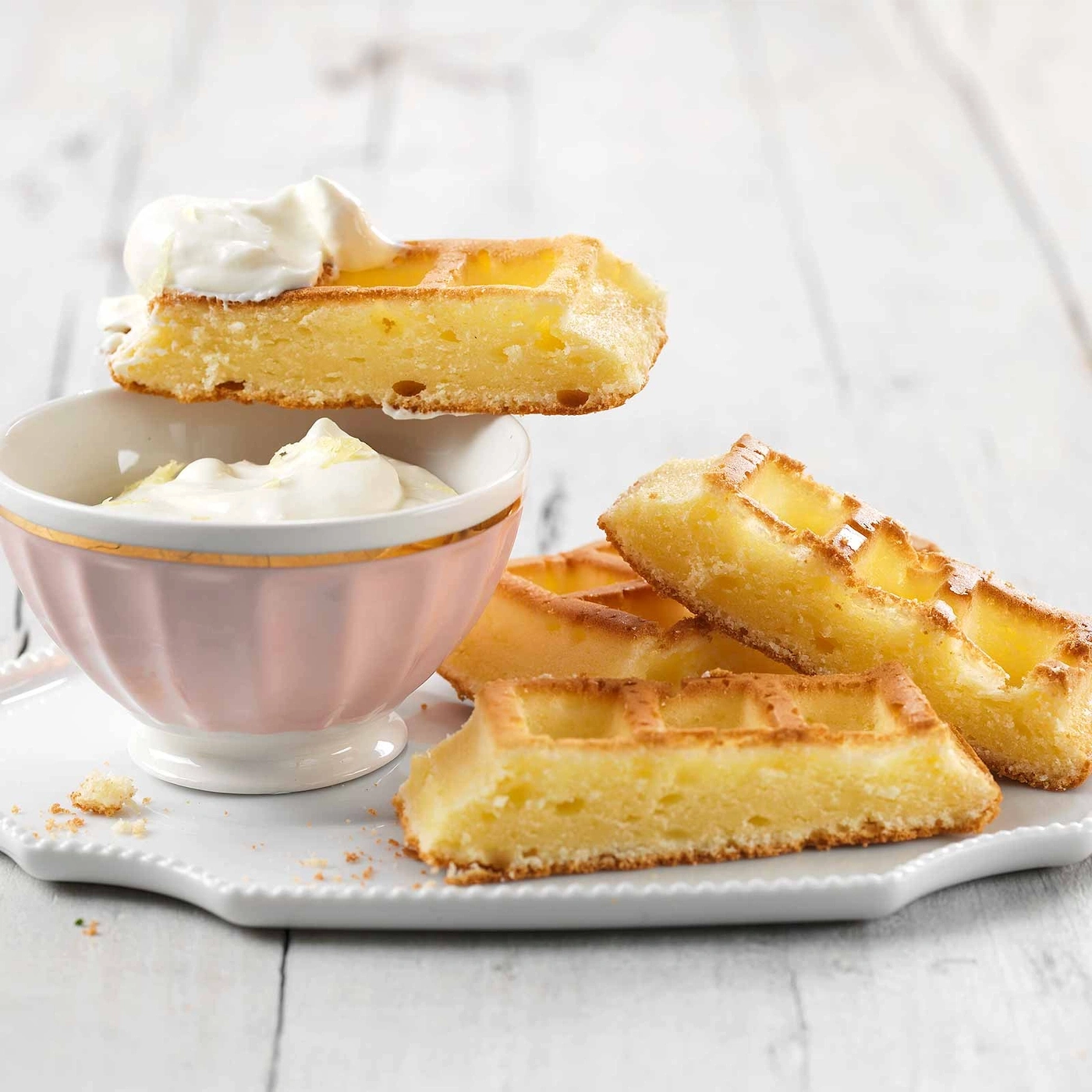 Waffeln mit Sahne in einer Schüssel auf einem Teller, Nahaufnahme.