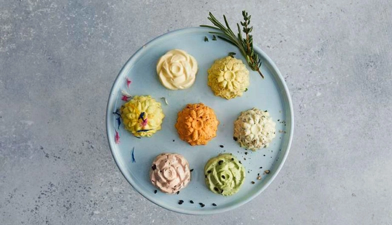 Teller mit bunten Butterblumen, Kräutern und Gewürzen, Nahaufnahme