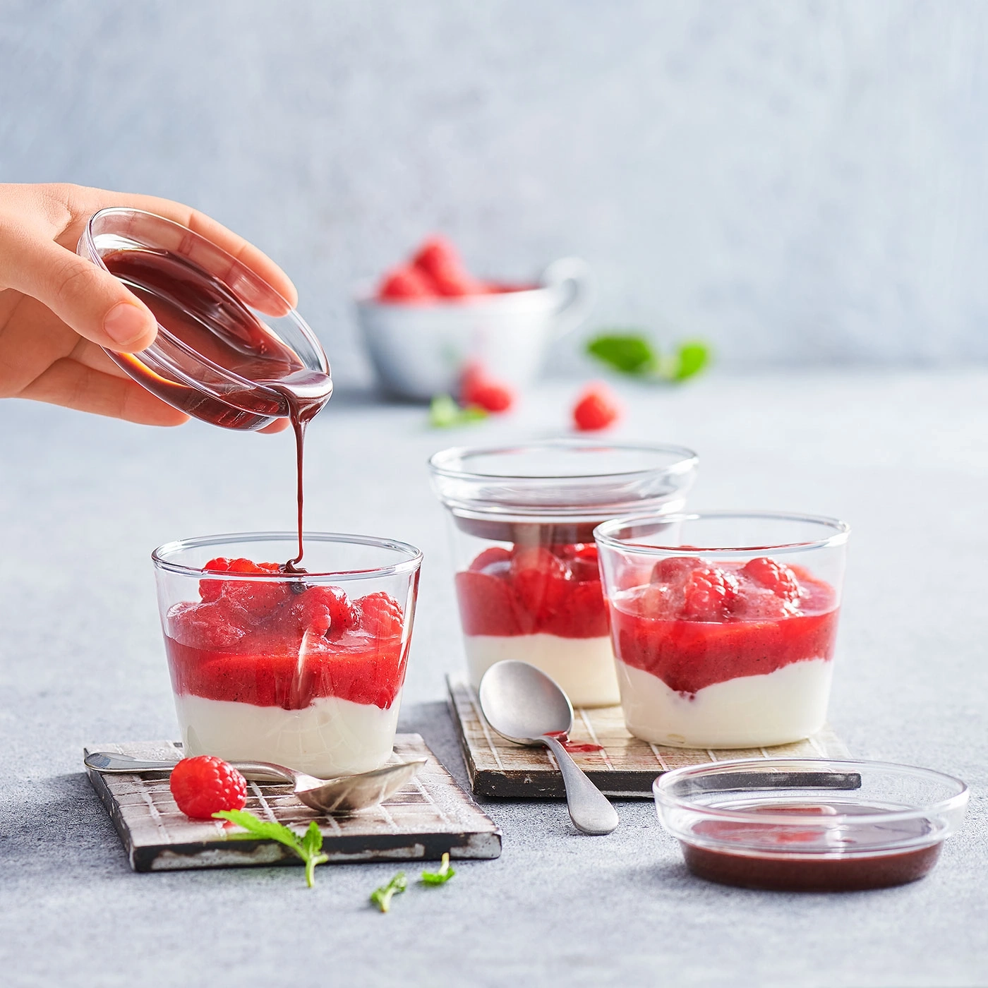 Dessert aux framboises et sauce au chocolat servi dans des verres.