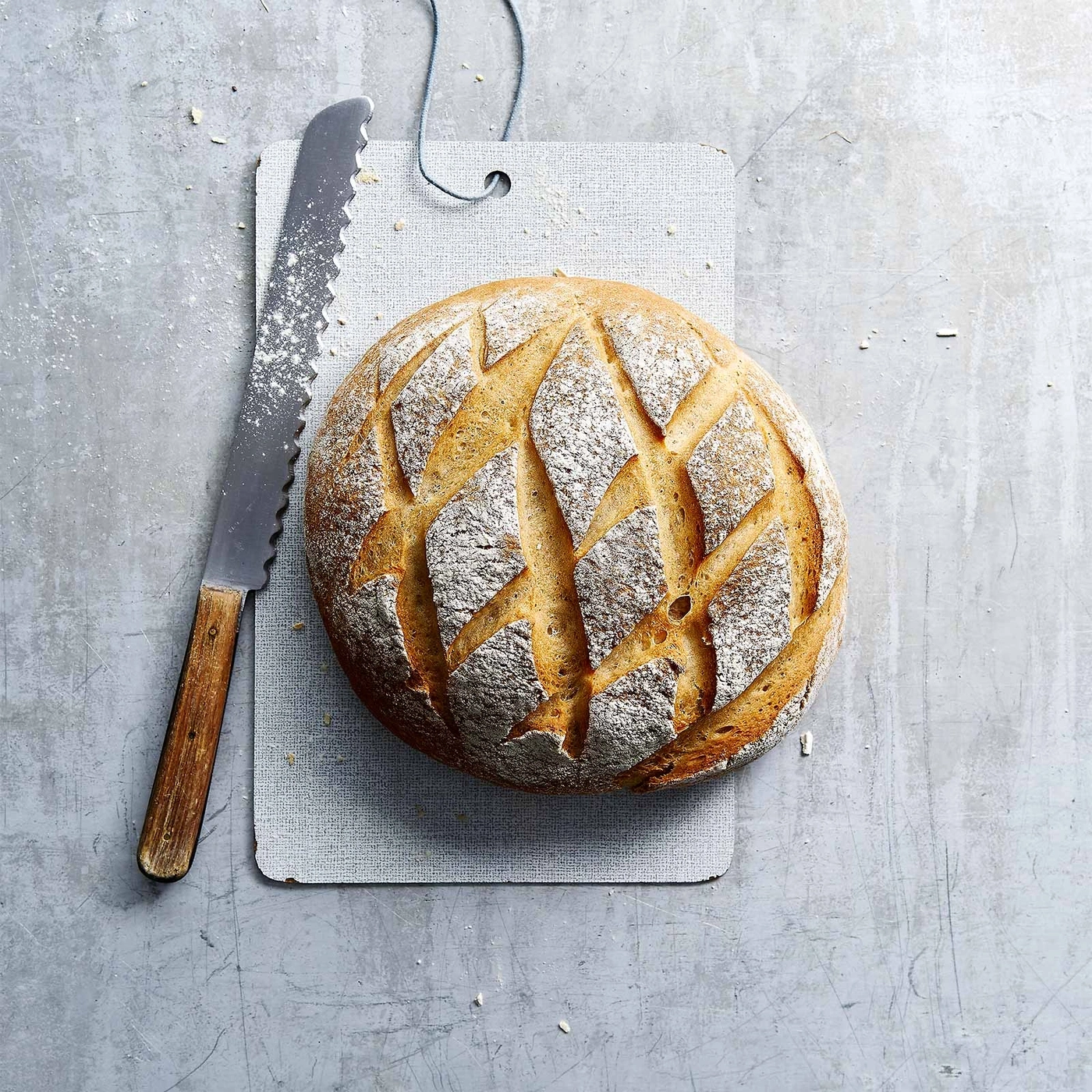 Brot auf Schneidebrett mit Messer, rustikal, frisch gebacken, lecker