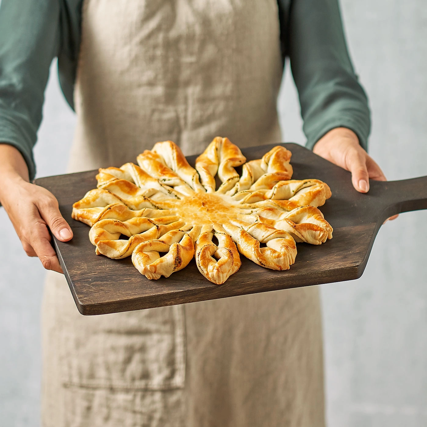 Une personne tient une pâtisserie en forme d'étoile sur une planche en bois. Délicieux!