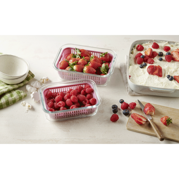 Fraises, framboises et myrtilles sur une table avec dessert et bols.