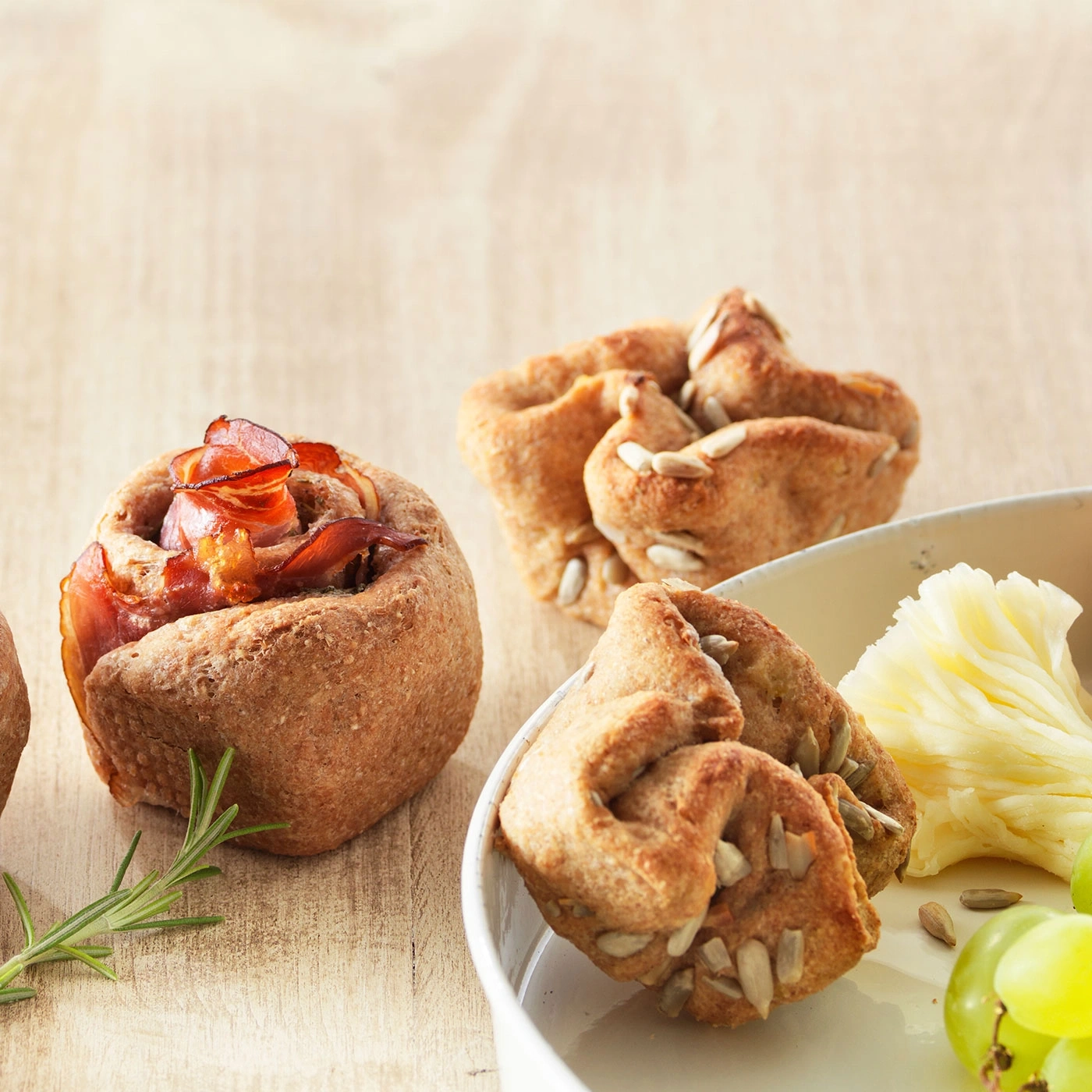 Délicieux petits pains avec du bacon, du fromage et des raisins dans une assiette.