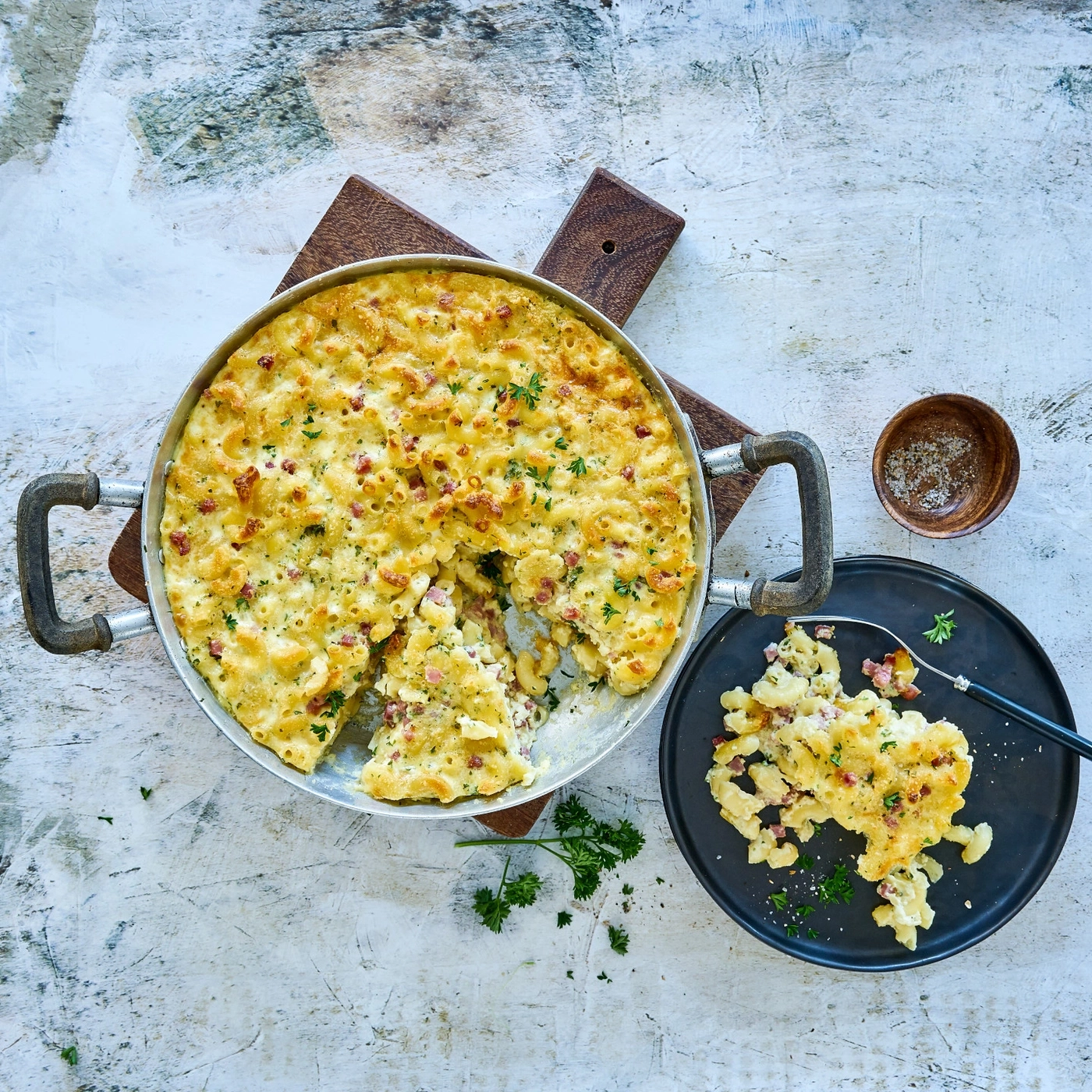 Plat de macaronis au fromage et au bacon, servi dans une poêle et sur une assiette