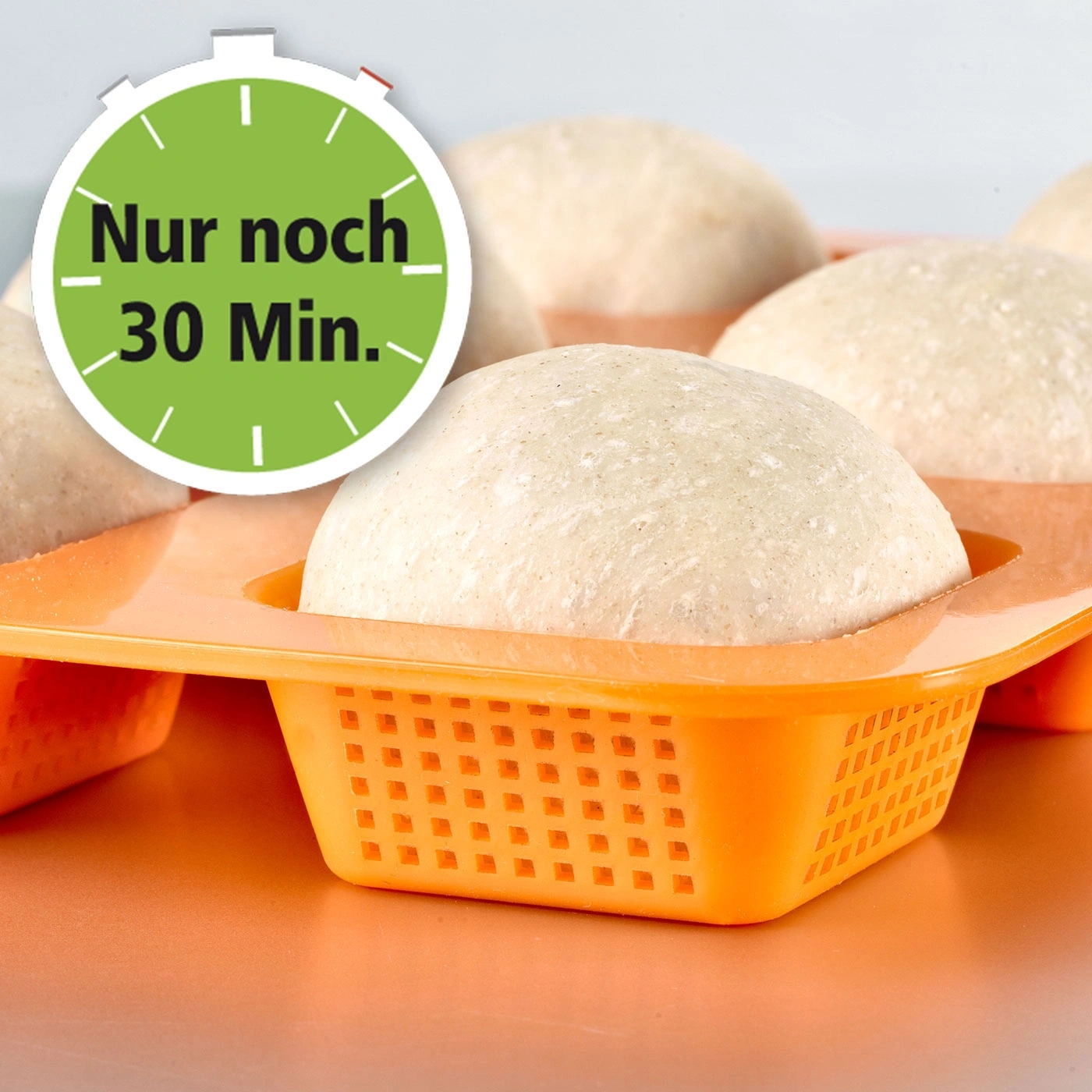 Des pâtons dans un moule avec une minuterie indiquant 30 minutes restantes.