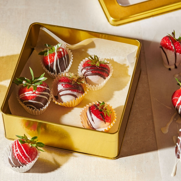 Fraises enrobées de chocolat dans une boîte dorée, délicieuses et sucrées