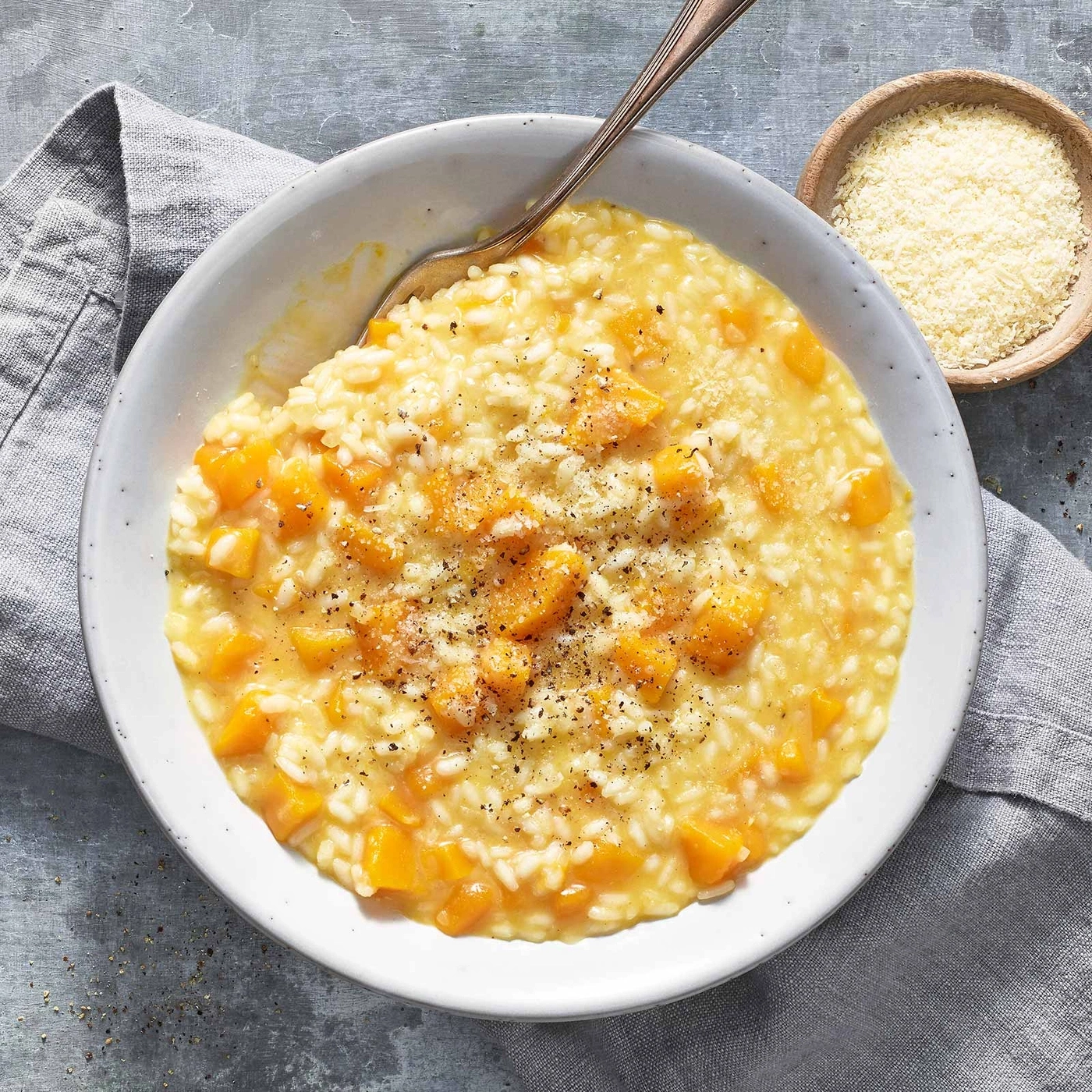 Kürbis-Risotto in einer Schüssel mit Parmesan und Pfeffer
