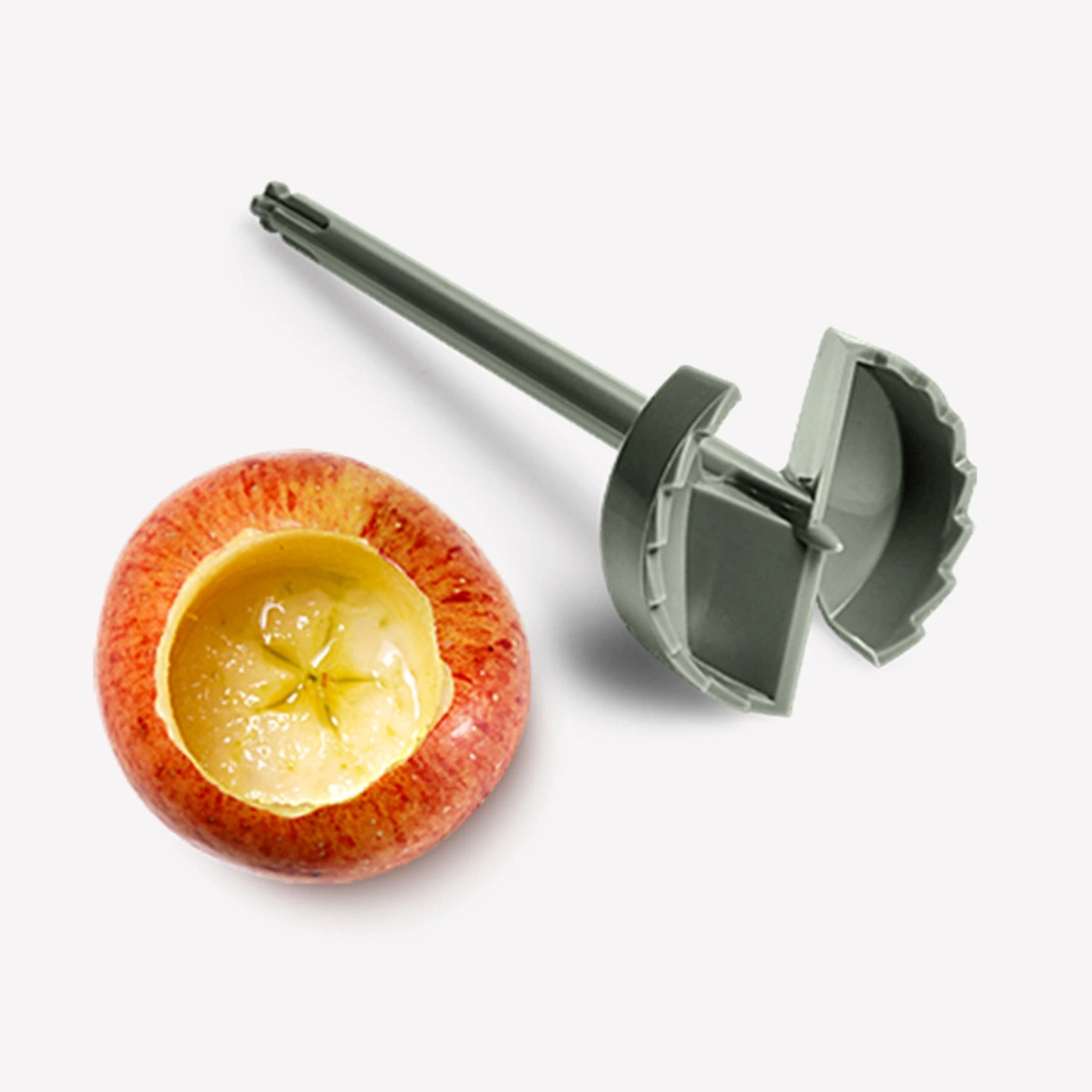 Apfel mit Loch und Werkzeug zum Aushöhlen, Nahaufnahme, weißer Hintergrund
