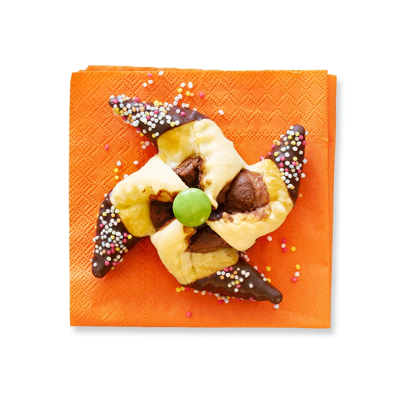 Gebäck mit Schokolade und Streuseln auf orangefarbenem Papier, Pinwheel-Form