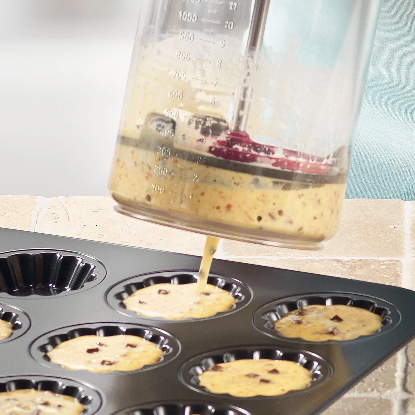 Teig wird in eine Kuchenform gegossen, um Muffins zu backen.